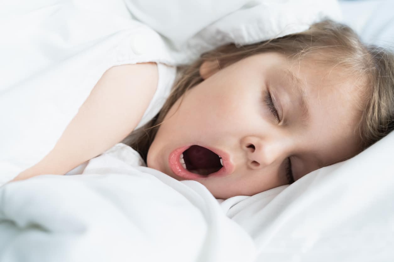 Young girl snoring in bed.