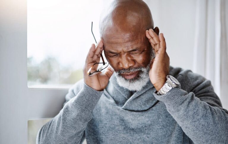 Man suffering from migraine headache.
